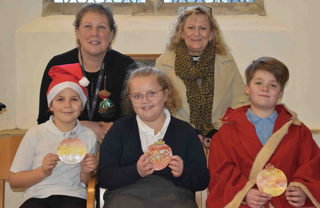Stanton Primary School and Nursery at the church that they have helped decorate in time for Christmas - with their teacher Mrs Smith and The Reverend Cathy Bladen