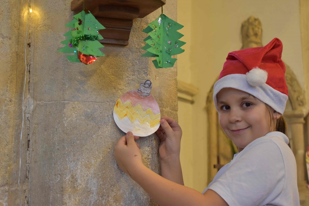 Savannah from Stanton Primary School and Nursery hanging decorations in the local church that students have made